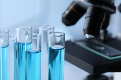 Test tubes with light blue liquid in laboratory, closeup