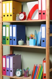 Colorful binder office folders and other stationery on shelving unit