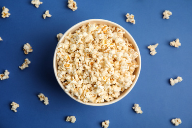 Photo of Tasty pop corn on blue background, flat lay