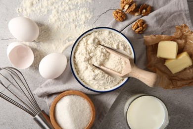 Photo of Different ingredients for dough and whisk on table, flat lay