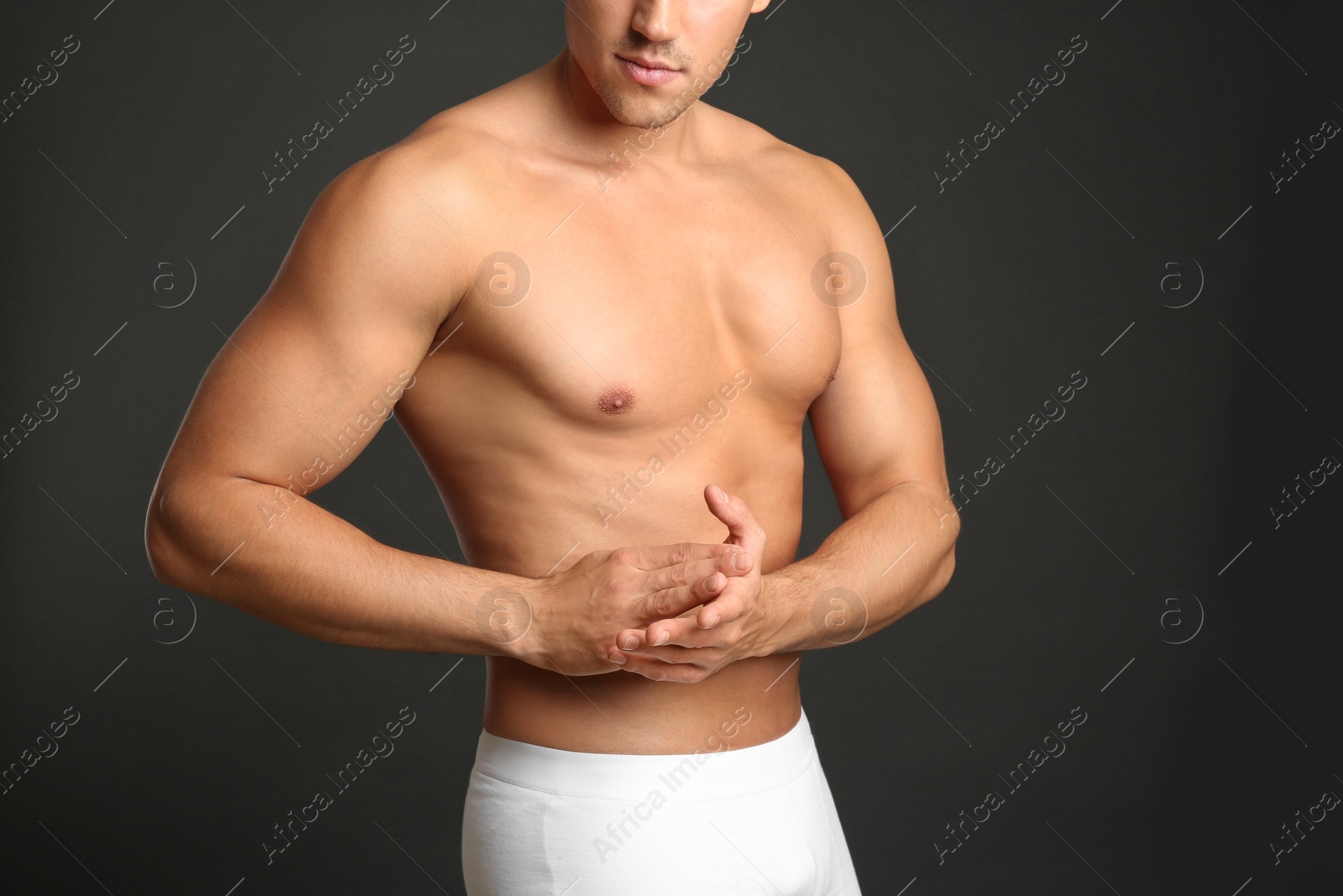 Photo of Man with sexy body on grey background, closeup