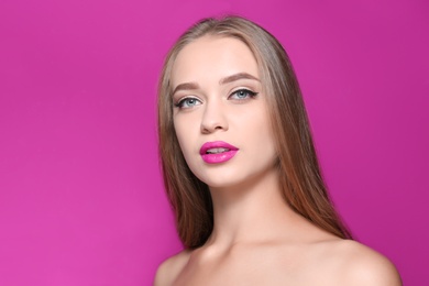 Beautiful young woman with perfect lips makeup on color background