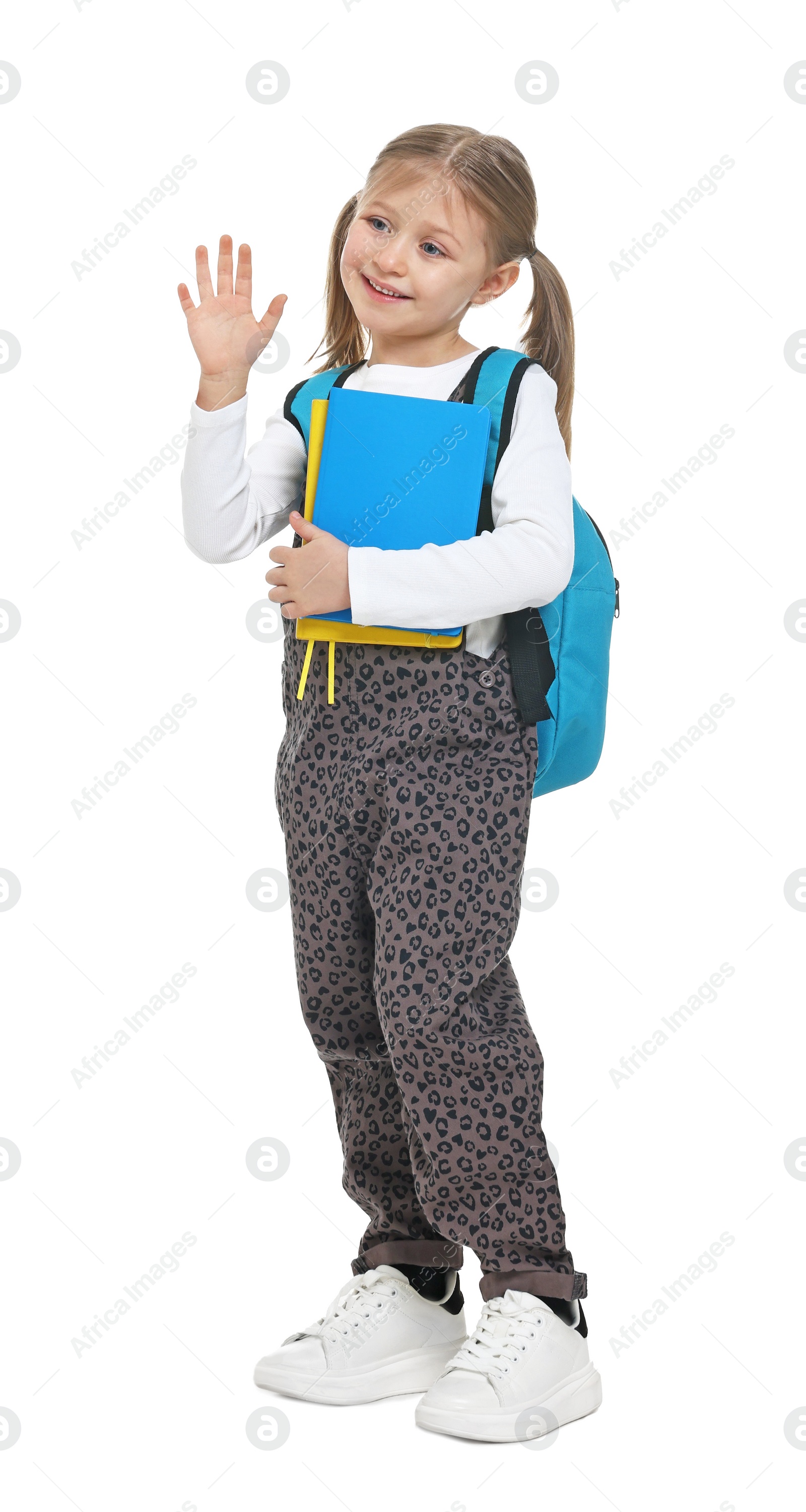 Photo of Cute schoolgirl with books greeting someone on white background