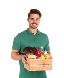 Young man holding wooden crate with products on white background. Food delivery service