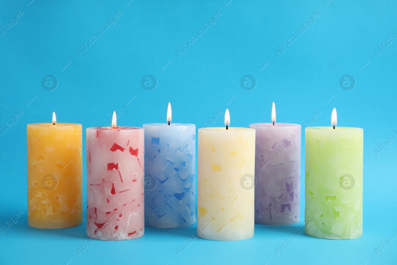 Photo of Alight scented wax candles on color background