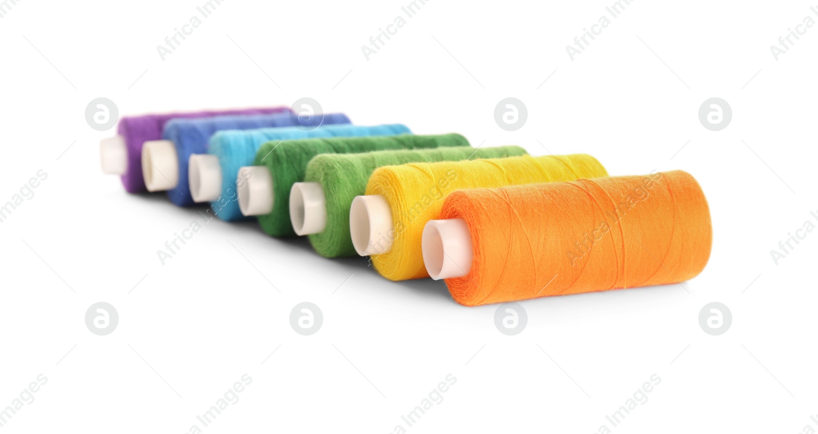 Photo of Set of colorful sewing threads on white background