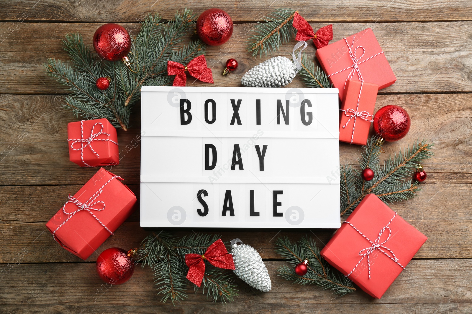 Photo of Flat lay composition with Boxing Day Sale sign and Christmas gifts on wooden table