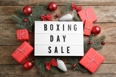 Flat lay composition with Boxing Day Sale sign and Christmas gifts on wooden table