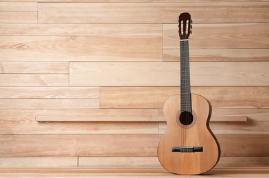 Photo of Beautiful classical guitar on wooden background. Space for text