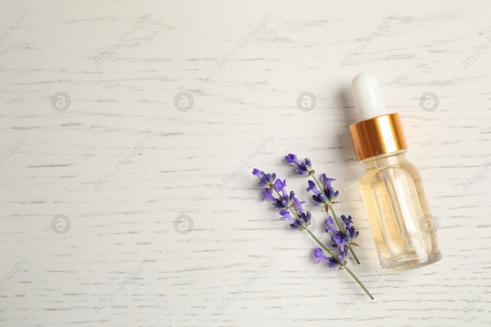 Photo of Flat lay composition with essential oil and lavender flowers on white wooden background. Space for text