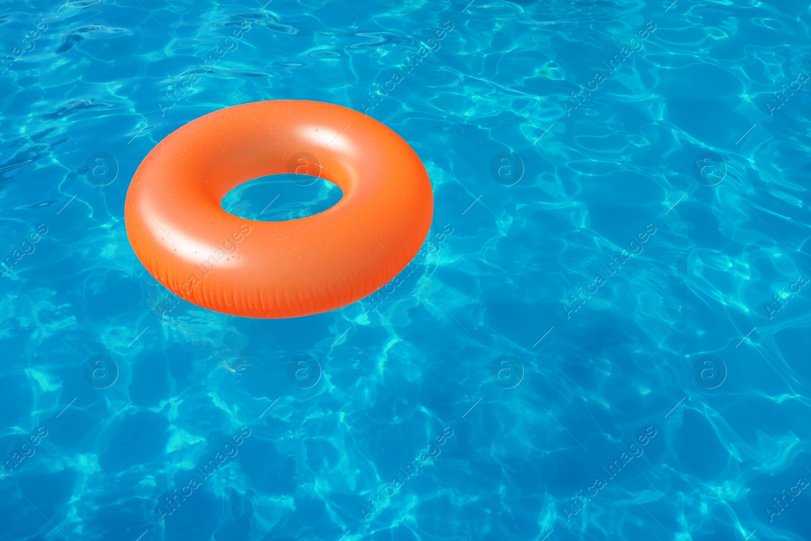 Photo of Inflatable ring floating in swimming pool on sunny day. Space for text