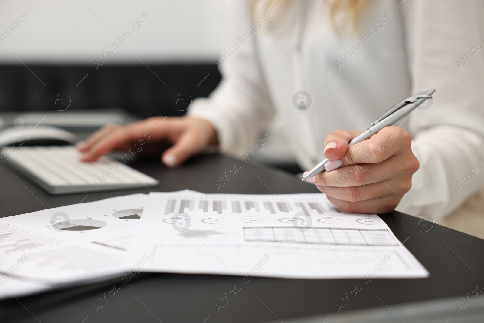 Photo of Secretary working with document at table in office, closeup