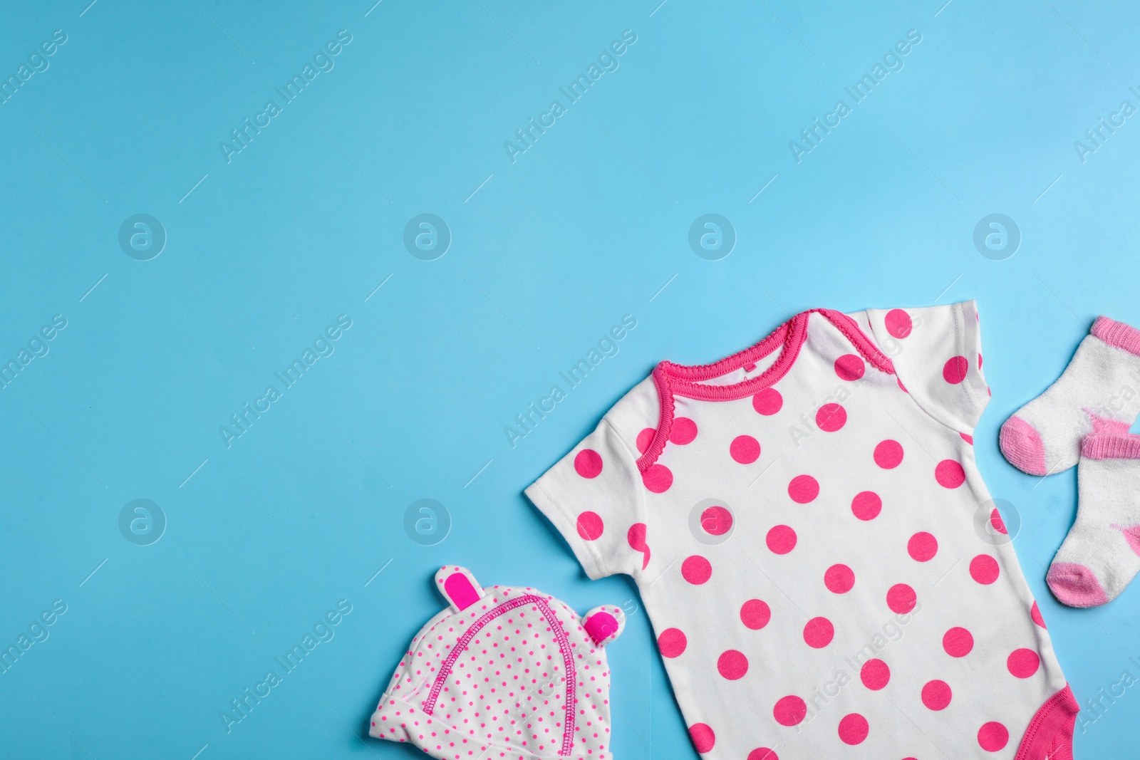 Photo of Flat lay composition with cute clothes and space for text on color background. Baby accessories