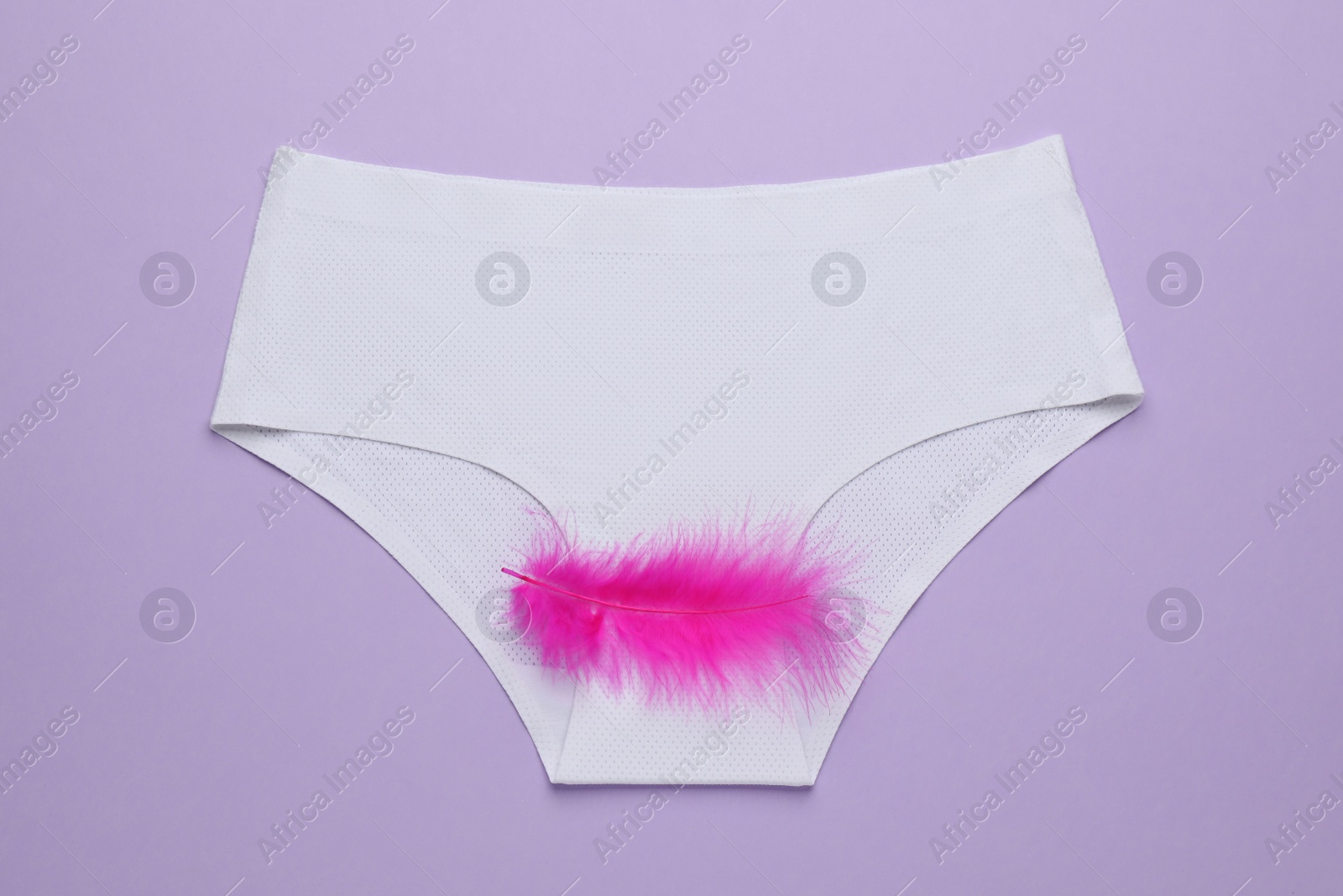 Photo of Woman's panties with pink feather on violet background, top view. Menstrual cycle