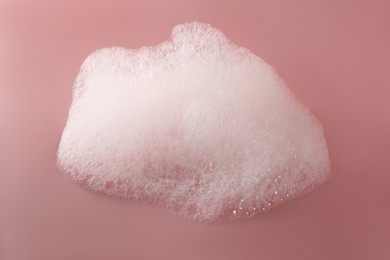 Photo of Fluffy bath foam on pink background, top view