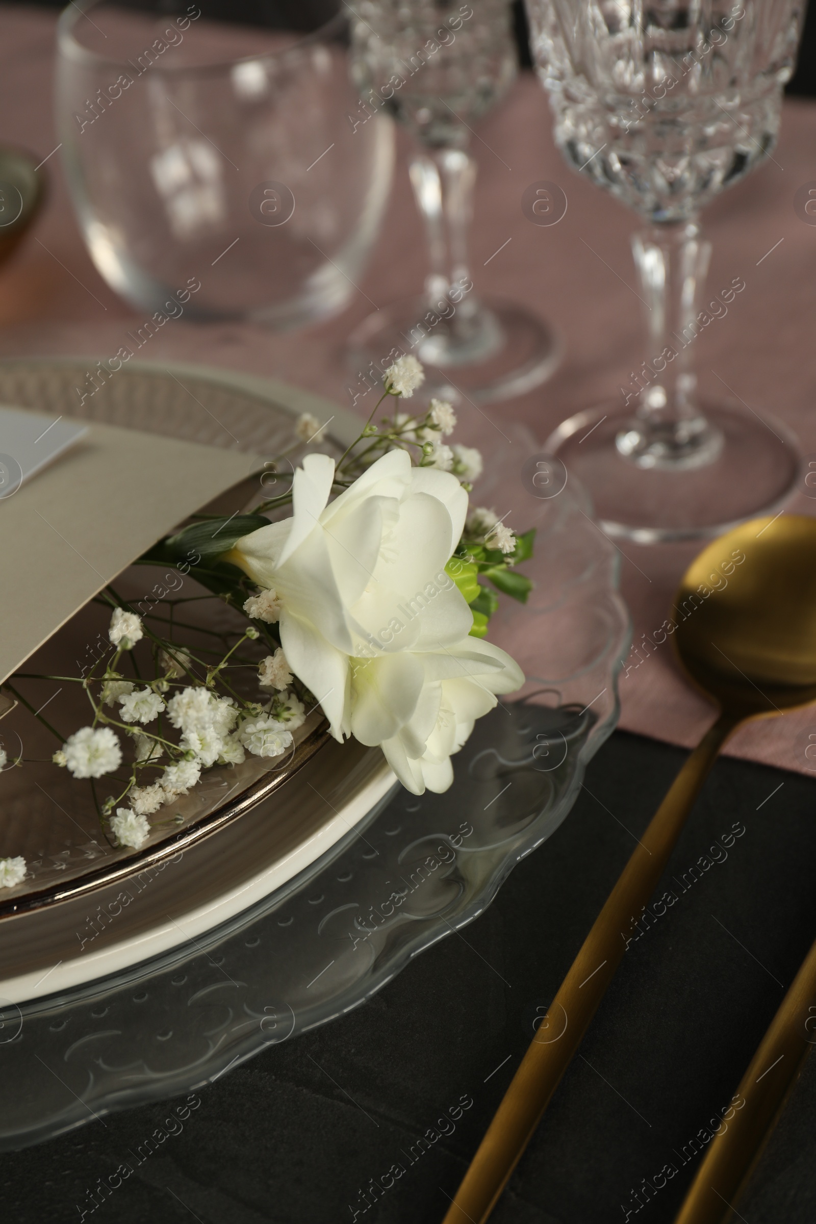 Photo of Stylish table setting with floral decor on black surface