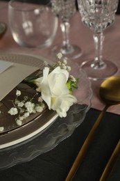 Photo of Stylish table setting with floral decor on black surface