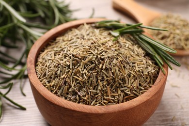 Photo of Bowl with dry and fresh rosemary on table, closeup