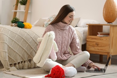 Woman learning to knit with online course at home. Handicraft hobby