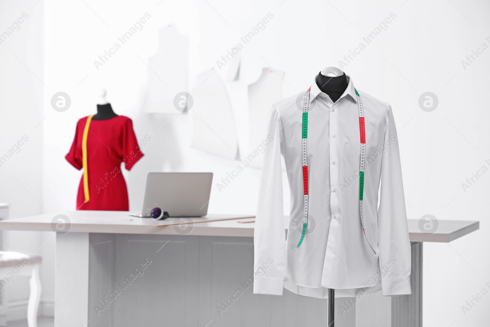 Photo of Mannequin with shirt and measuring tape in tailor studio