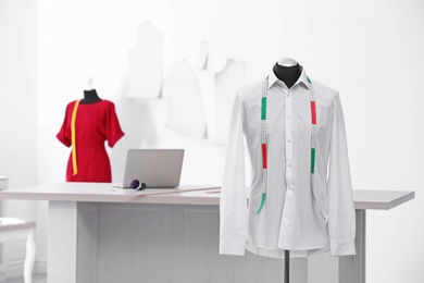 Photo of Mannequin with shirt and measuring tape in tailor studio
