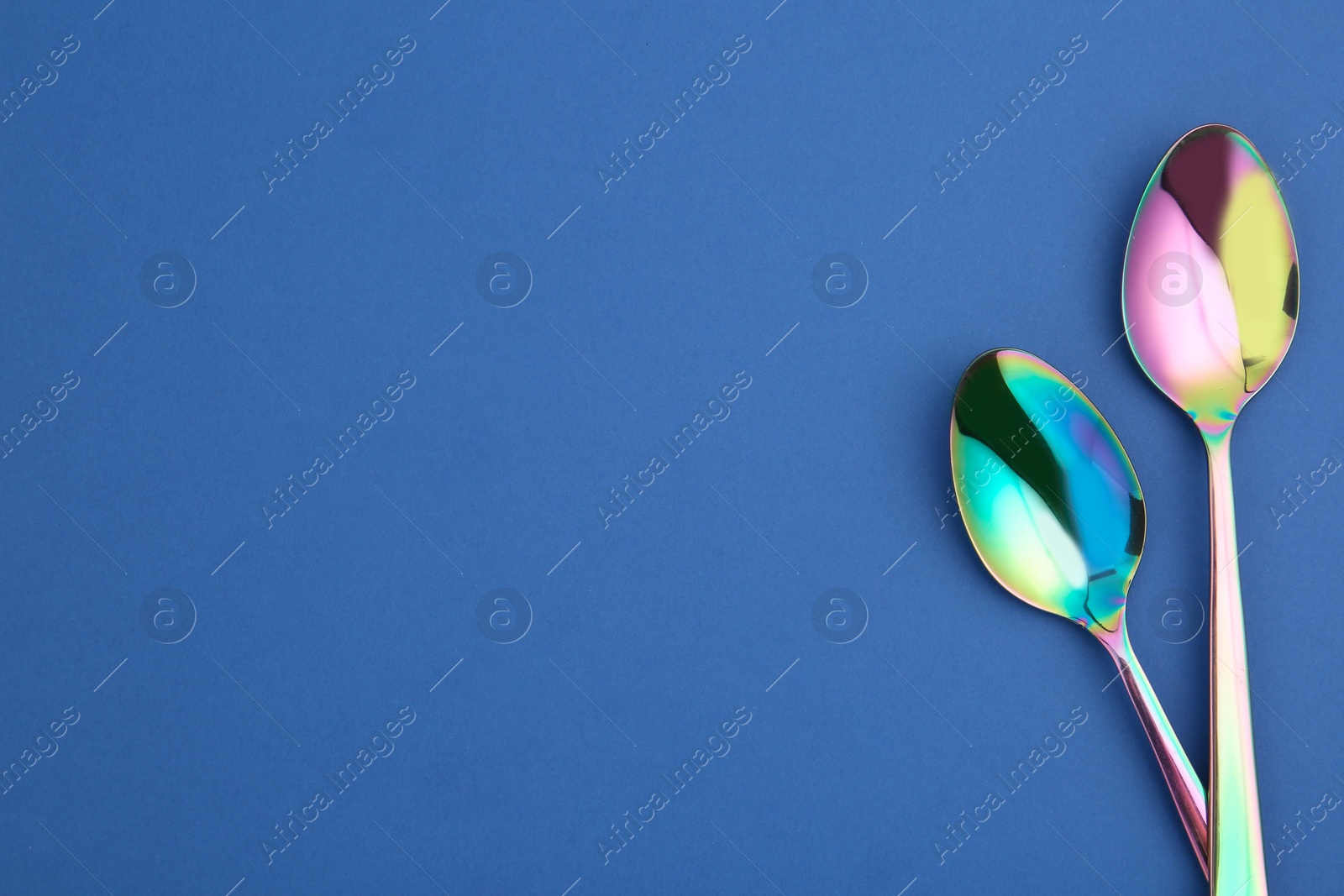 Photo of Clean tablespoons and space for text on color background, flat lay