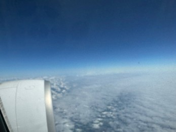 Photo of Beautiful blue sky with fluffy clouds, view from plane window