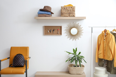 Photo of Hallway interior with stylish furniture, clothes and accessories
