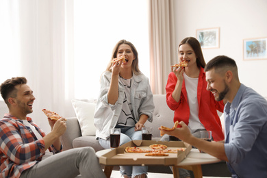 Group of friends eating tasty pizza at home