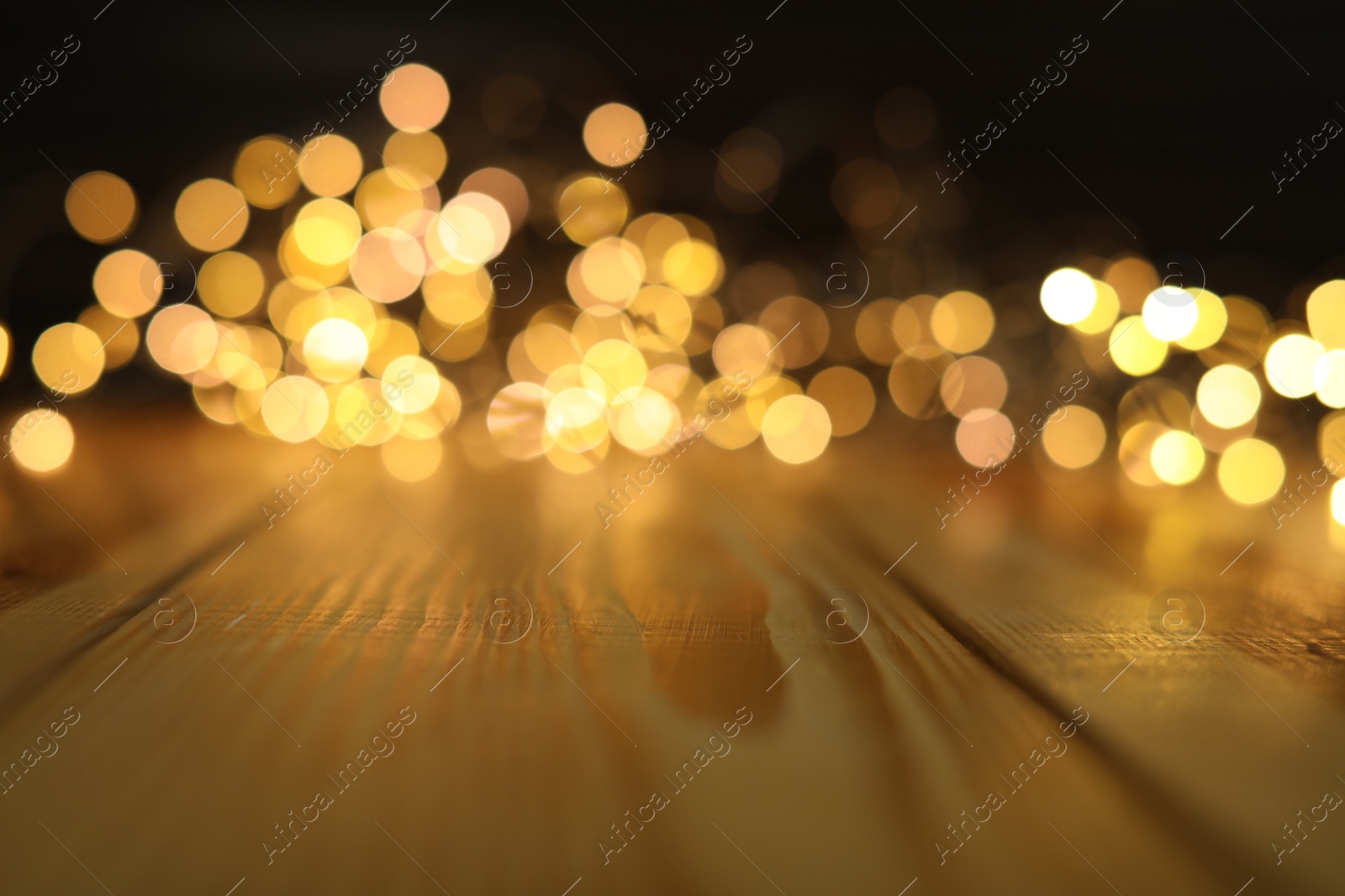 Photo of Empty wooden surface and blurred lights on background. Bokeh effect