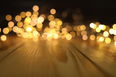 Empty wooden surface and blurred lights on background. Bokeh effect