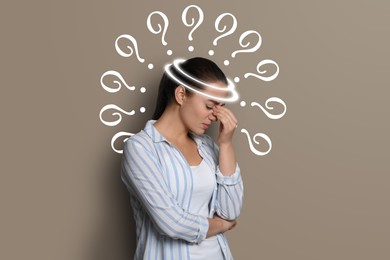 Image of Amnesia concept. Woman surrounded by question marks trying to remember something on beige background