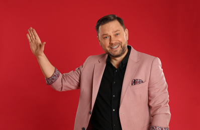 Photo of Portrait of happy mature man on red background