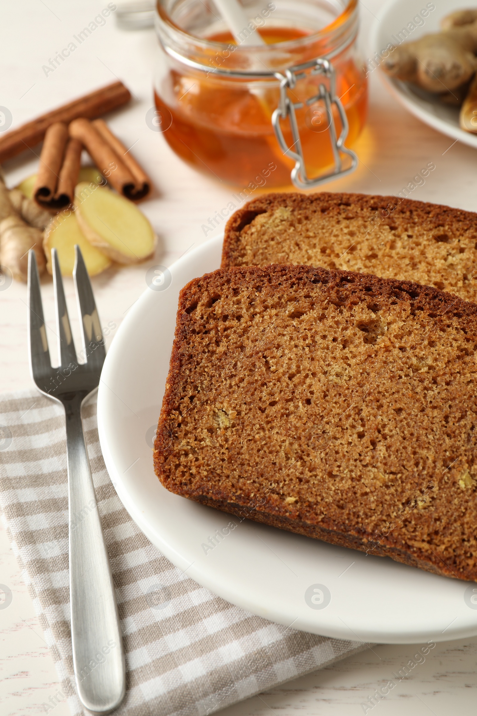 Photo of Fresh gingerbread cake slices served on white wooden table, closeup