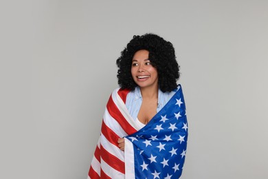 Photo of 4th of July - Independence Day of USA. Happy woman with American flag on light grey background