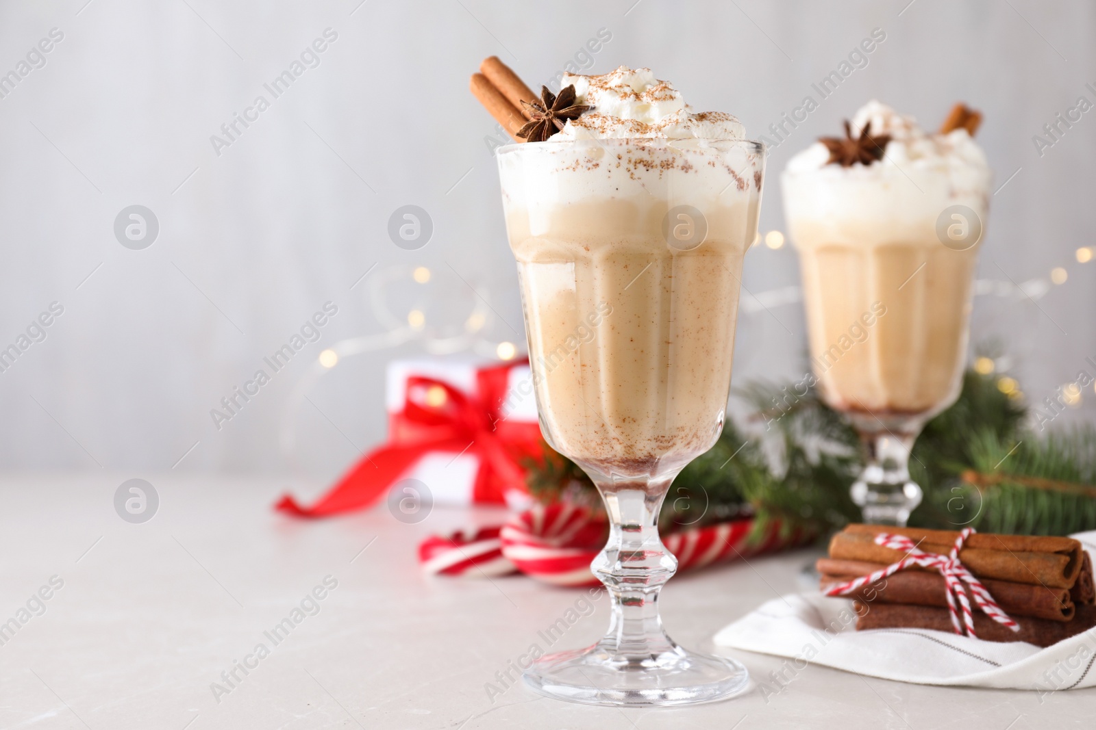 Photo of Delicious Christmas cocktail with liqueur on white table. Space for text