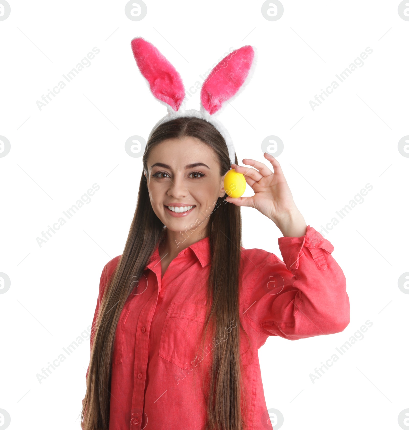 Photo of Beautiful woman in bunny ears headband holding Easter egg on white background