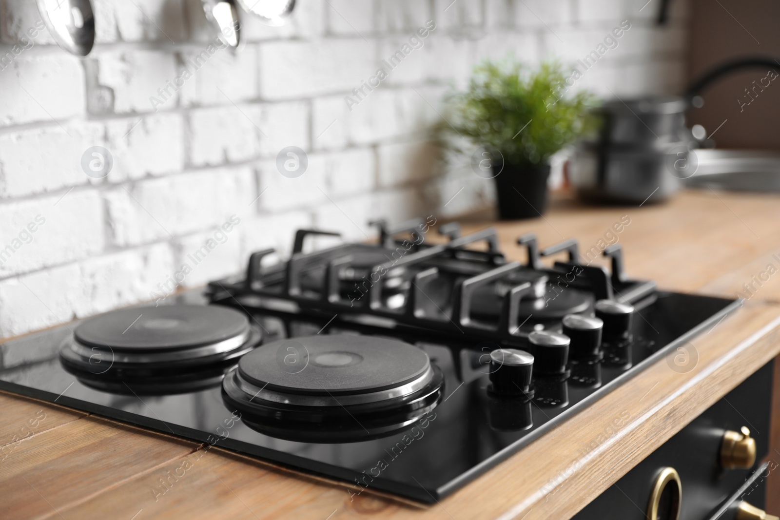 Photo of New modern stove with gas and electric burners in kitchen