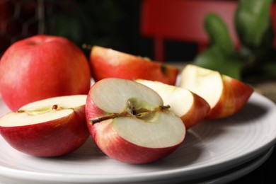 Photo of Fresh red apples on white plate, closeup