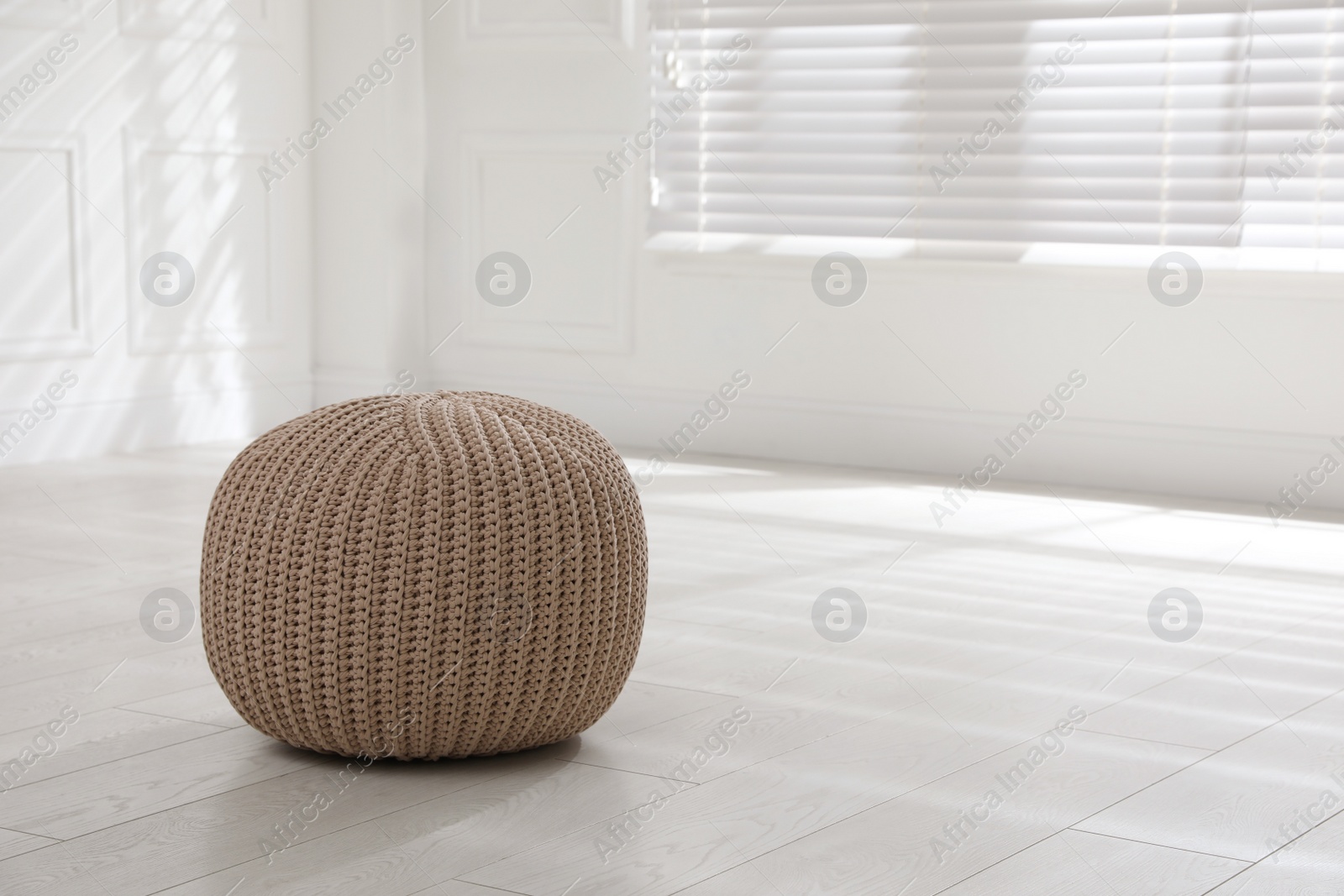Photo of Stylish beige pouf in room, space for text