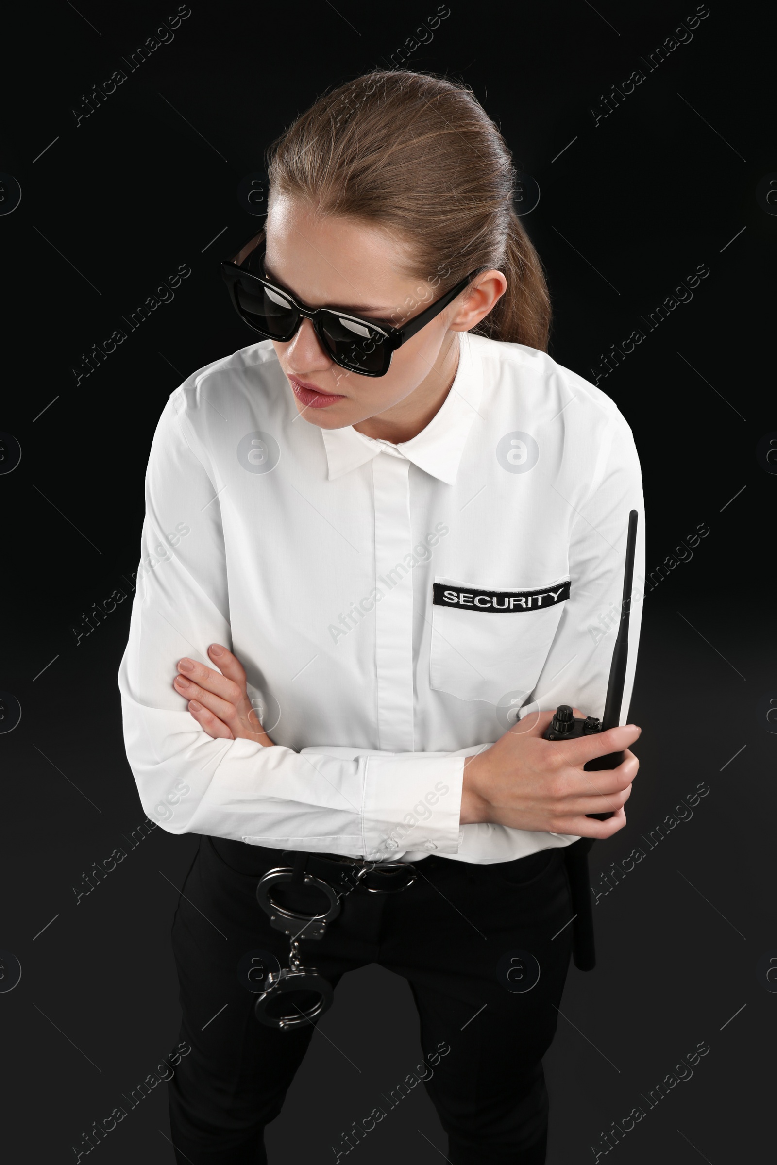 Photo of Female security guard with portable radio transmitter on dark background