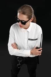 Photo of Female security guard with portable radio transmitter on dark background