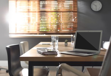 Image of Modern laptop on wooden table in office. Comfortable workplace 