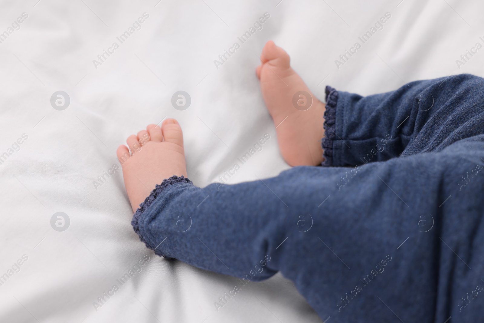 Photo of Newborn baby lying on white blanket, closeup