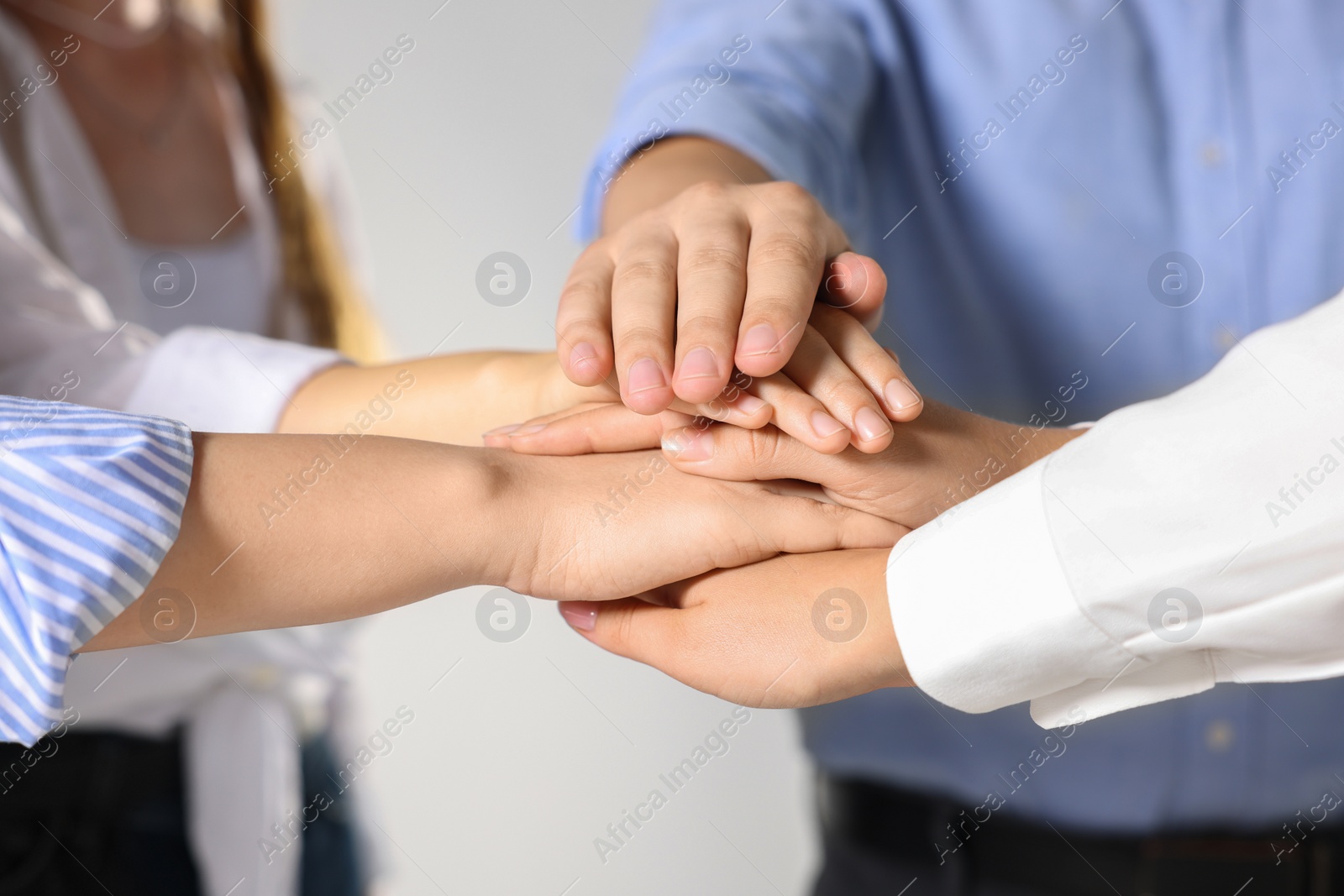 Photo of Group of people holding hands together indoors, closeup. Unity concept