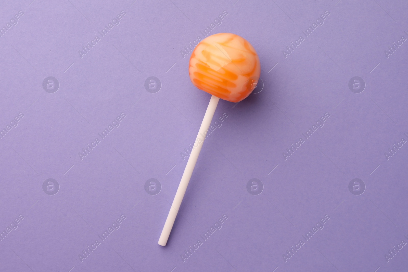 Photo of Tasty lollipop on violet background, top view