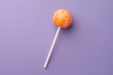 Tasty lollipop on violet background, top view