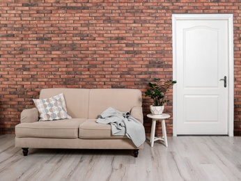 Photo of Modern room interior with white door and comfortable sofa