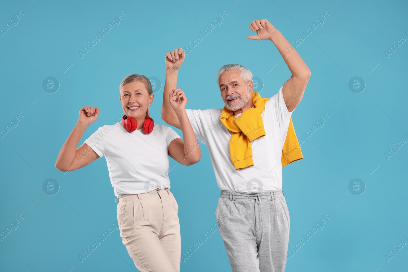 Photo of Senior couple dancing together on light blue background