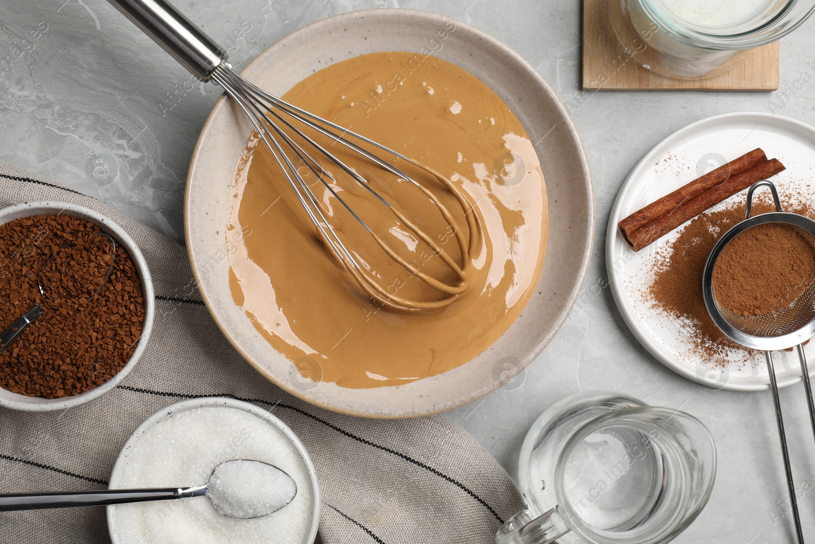 Photo of Whipping cream for dalgona coffee and ingredients on light gray table, flat lay